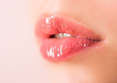 Natural beauty lip care. Female lips with pink lipstick. Sensual tenderness womens open mouths. Red lip with glossy lipgloss. Close up, macro with beautiful mouths. Sensual lips of a young woman